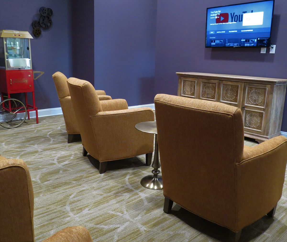 A modern lounge area with comfortable chairs and a wall-mounted television.
