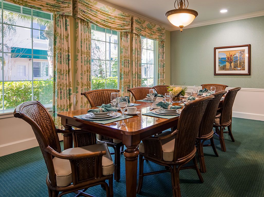 A well-set dining room with a long table, chairs, and elegant decor.