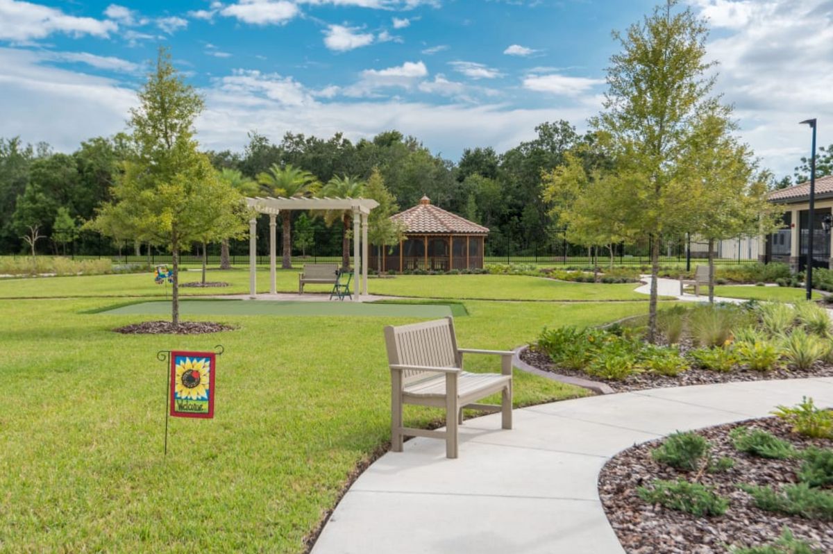 A serene park setting with a gazebo, pathways, and neatly landscaped greenery.
