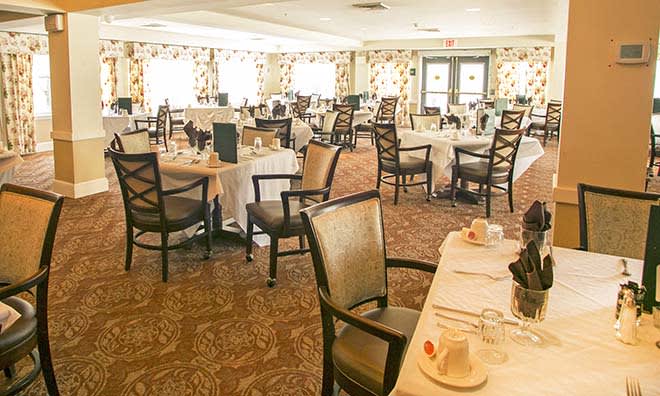 An elegant dining room with neatly arranged tables and chairs.