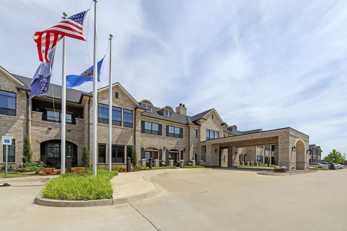 A large building with flags at the entrance on a clear day.