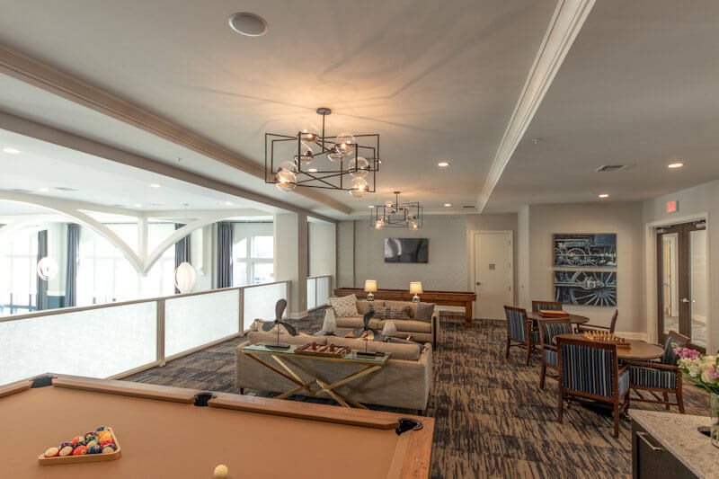 A modern game room featuring a pool table and cozy seating area.