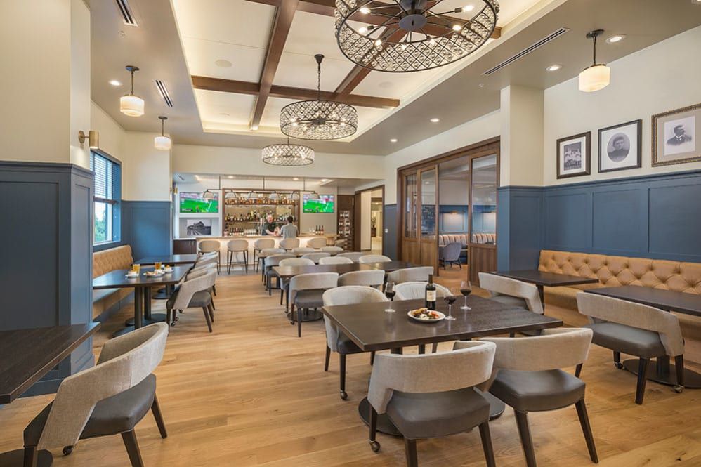 A cozy restaurant interior featuring a spacious dining area with modern decor and wooden flooring.
