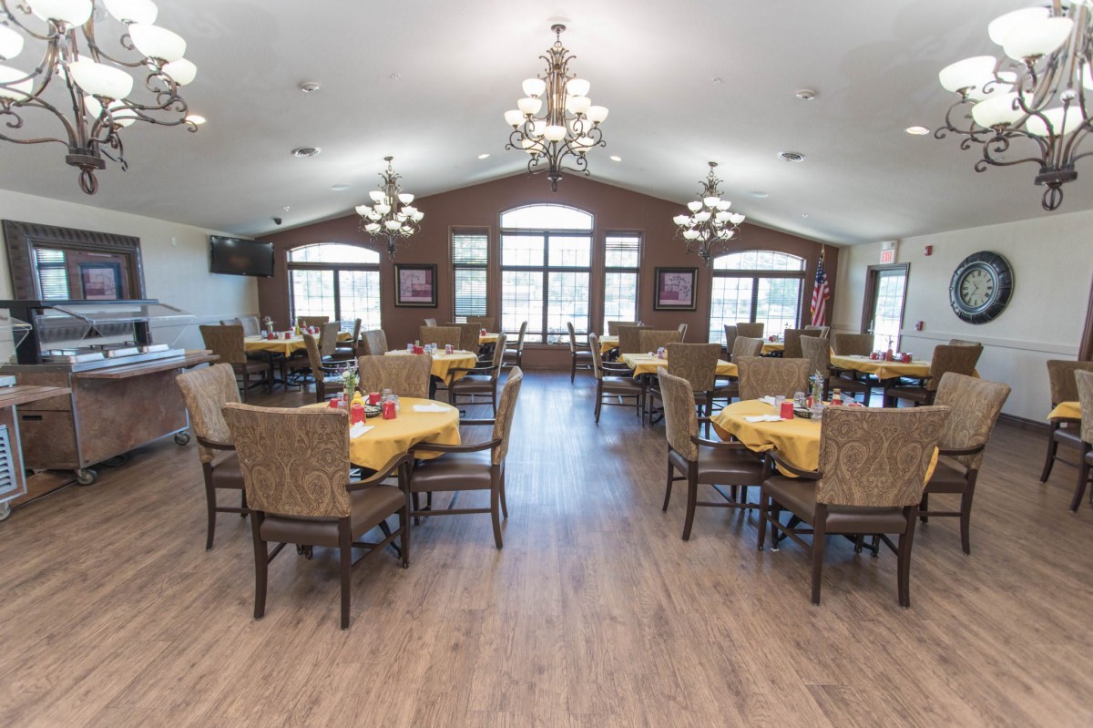 Spacious dining area with arranged tables and chandeliers.