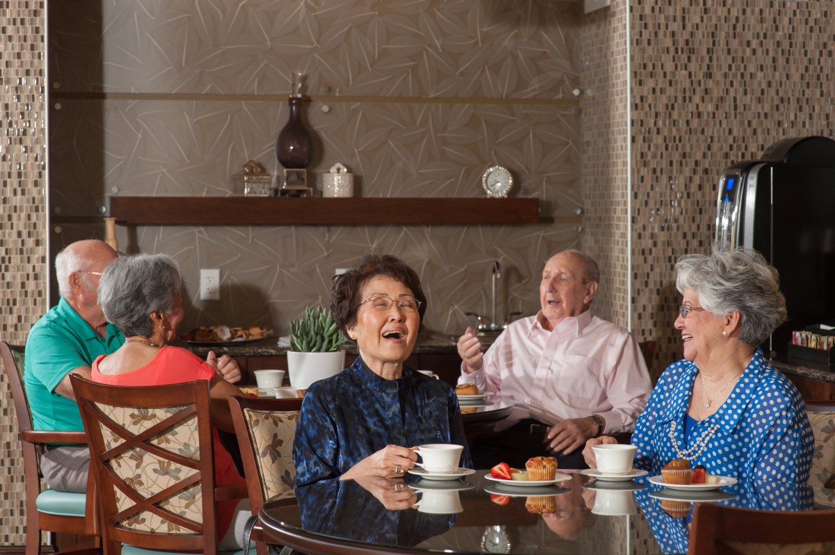 A group of seniors enjoying coffee and conversation in a cozy indoor setting.