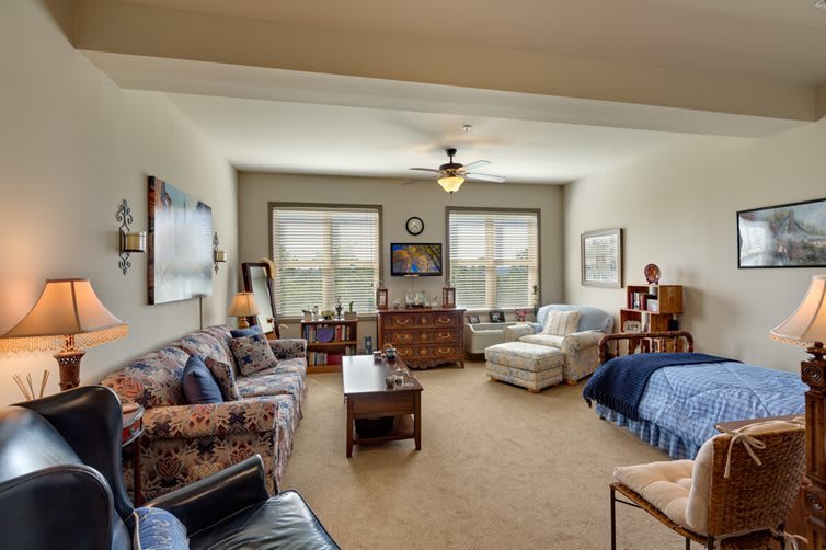 A cozy living room featuring comfortable seating, a coffee table, and large windows allowing natural light to fill the space.