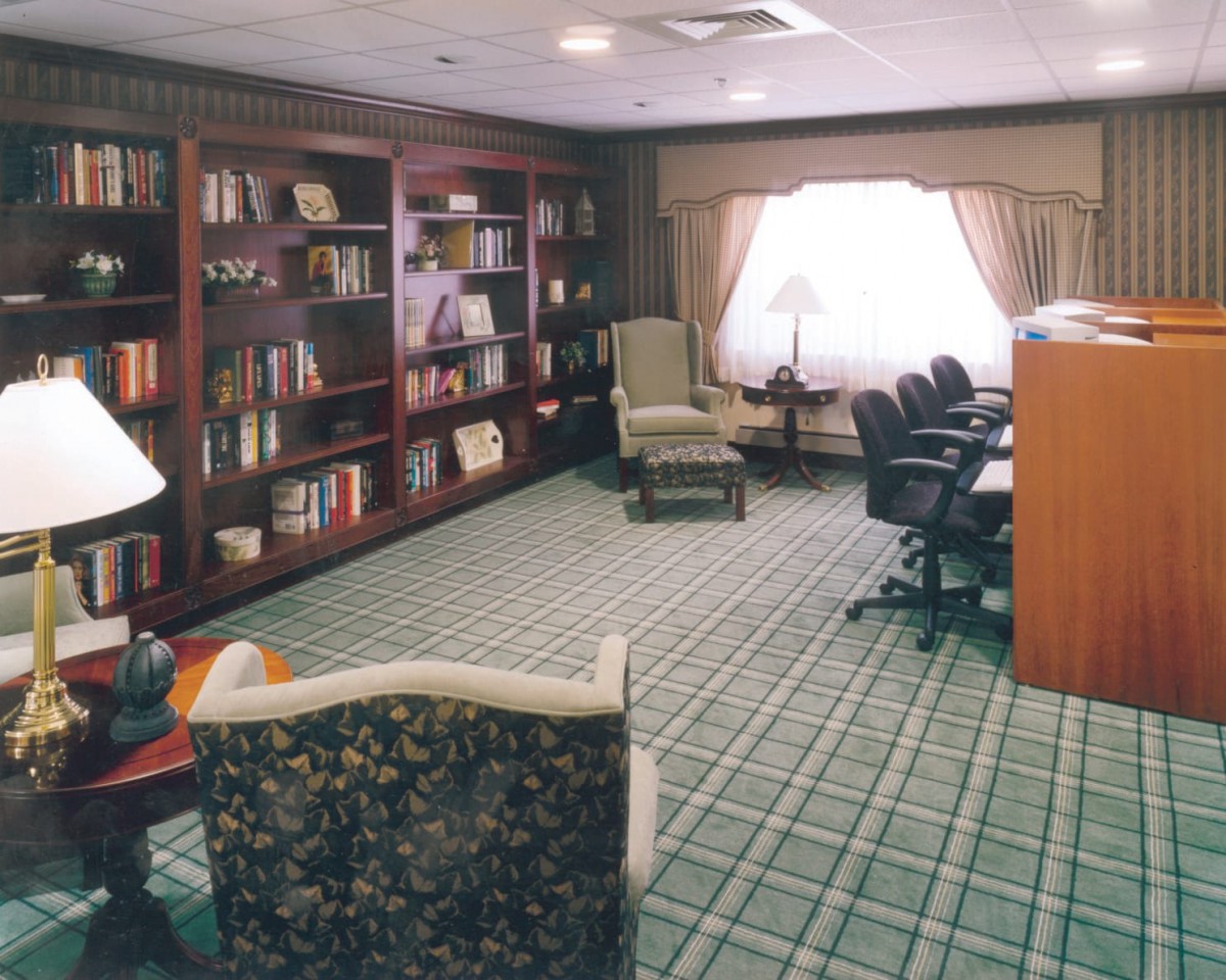 A cozy library-style meeting room with bookshelves and comfortable seating.