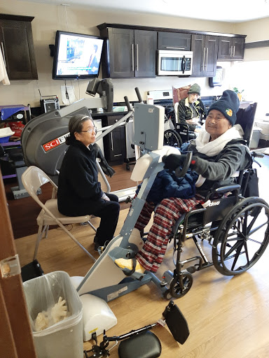A patient engages in rehabilitation therapy with the assistance of a caregiver in a healthcare facility.