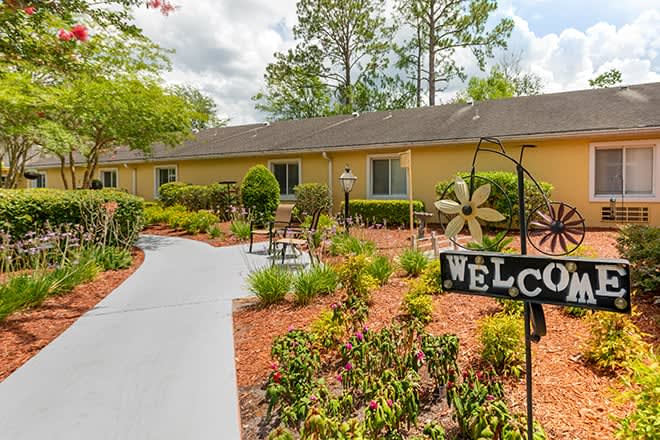 A welcoming garden path leading to a building, adorned with shrubs and landscaping.