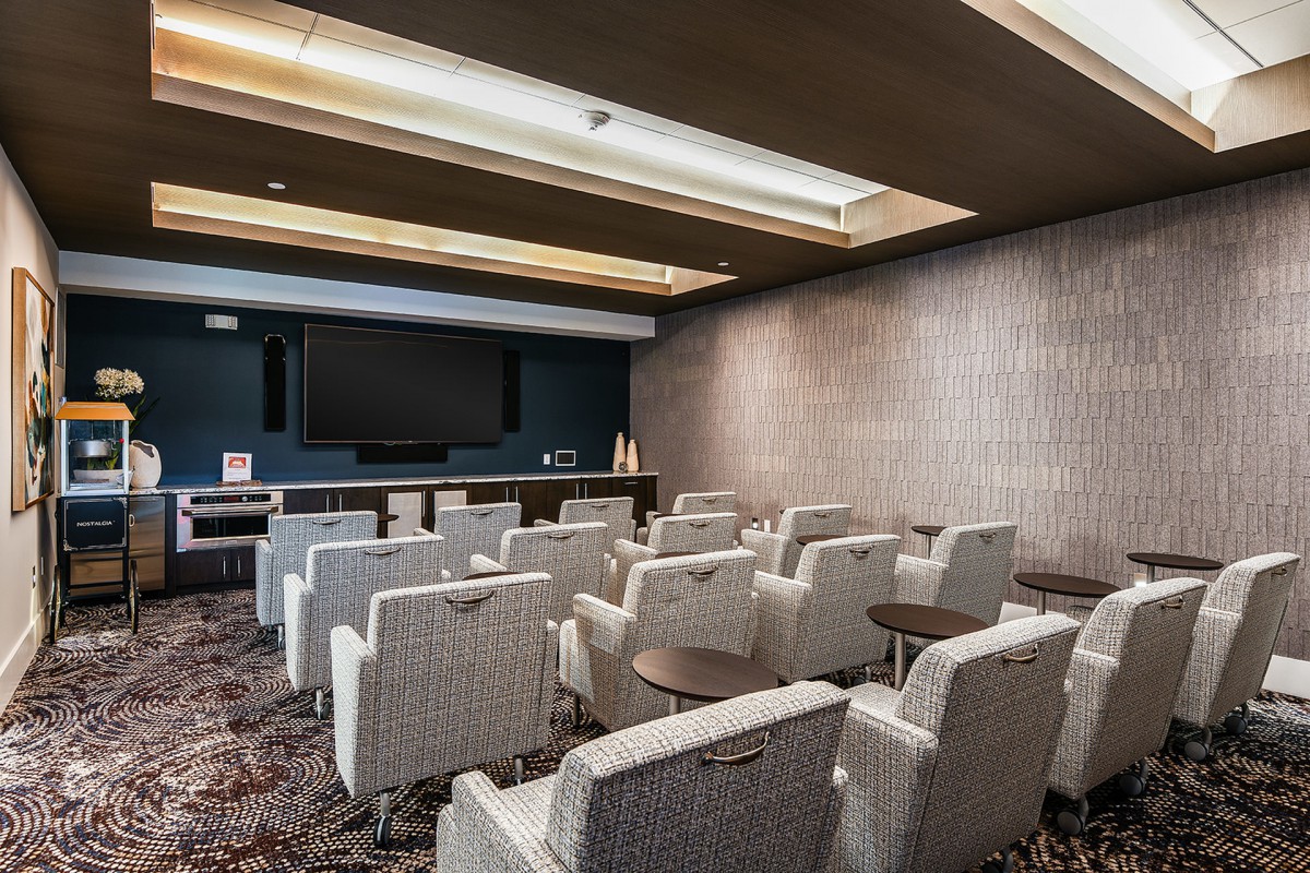 A modern home theater with plush seating and a large projector screen.