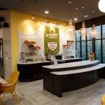 A cozy cafe interior featuring a modern counter and comfortable seating area.