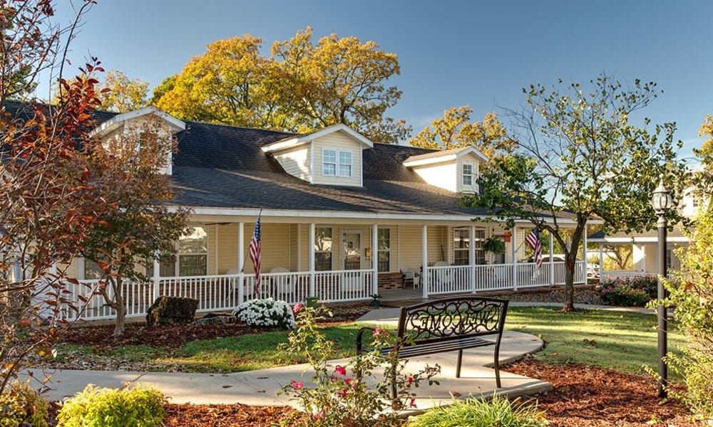 A charming house with a wraparound porch and well-maintained garden.