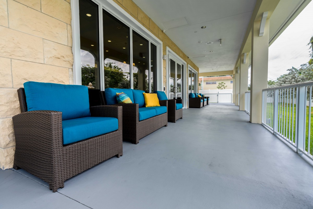 A spacious patio area featuring comfortable rattan furniture with blue cushions.
