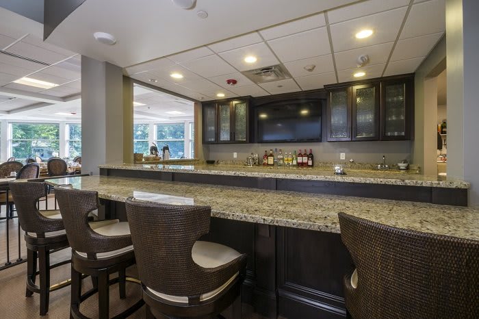 A modern bar with a granite countertop and comfortable seating.