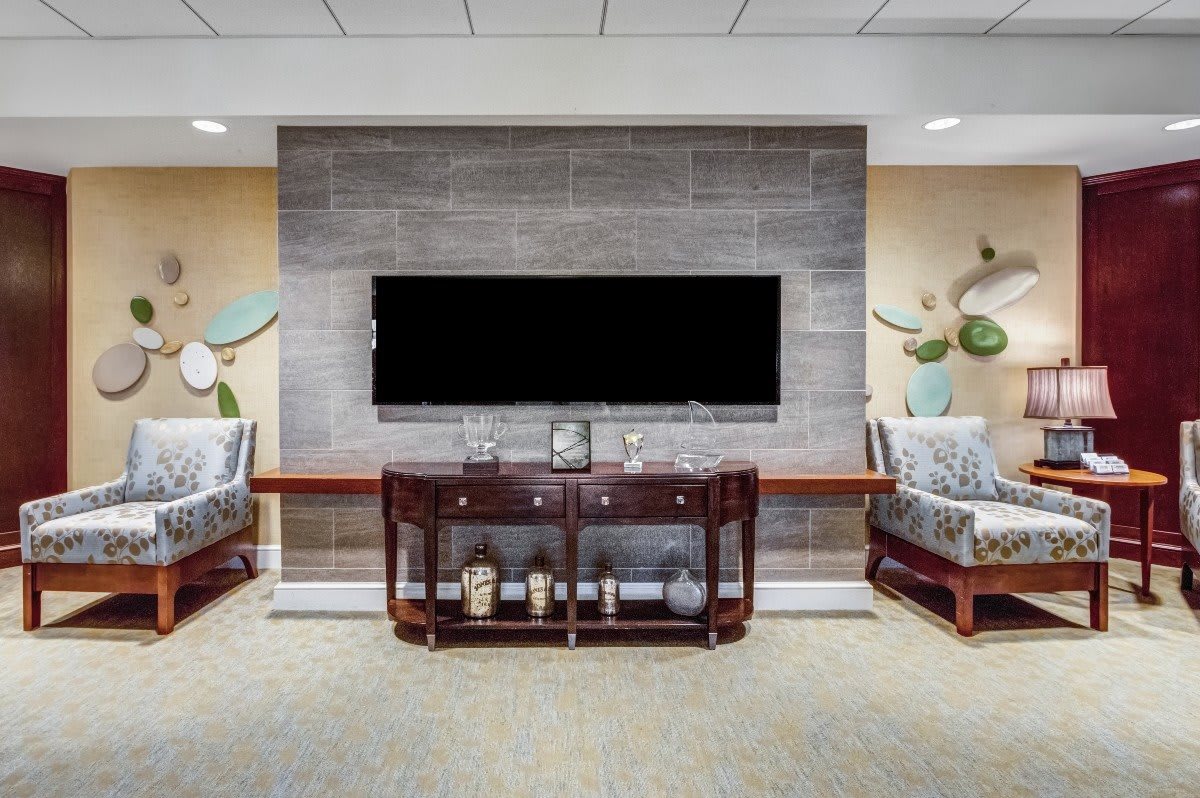A stylish living room with a mounted TV, console table, and comfortable seating.