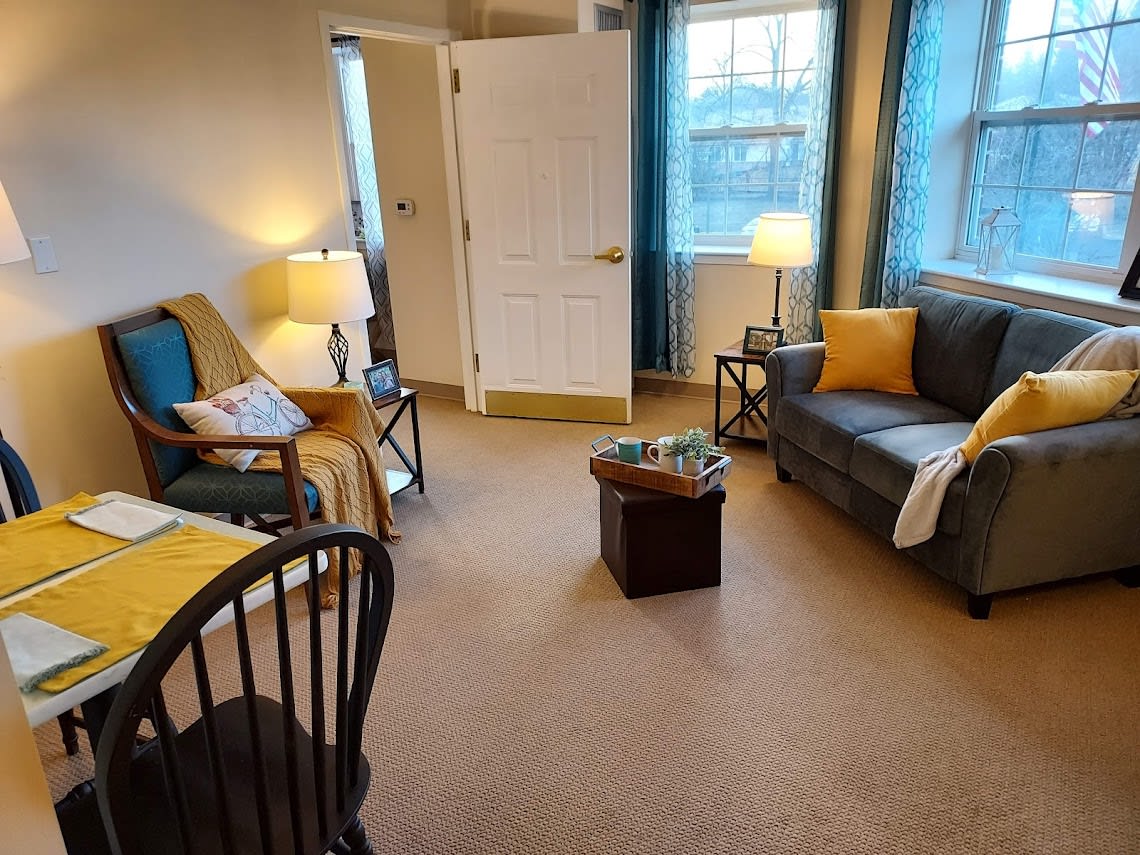 A cozy living room with a sofa, chairs, and warm lighting.