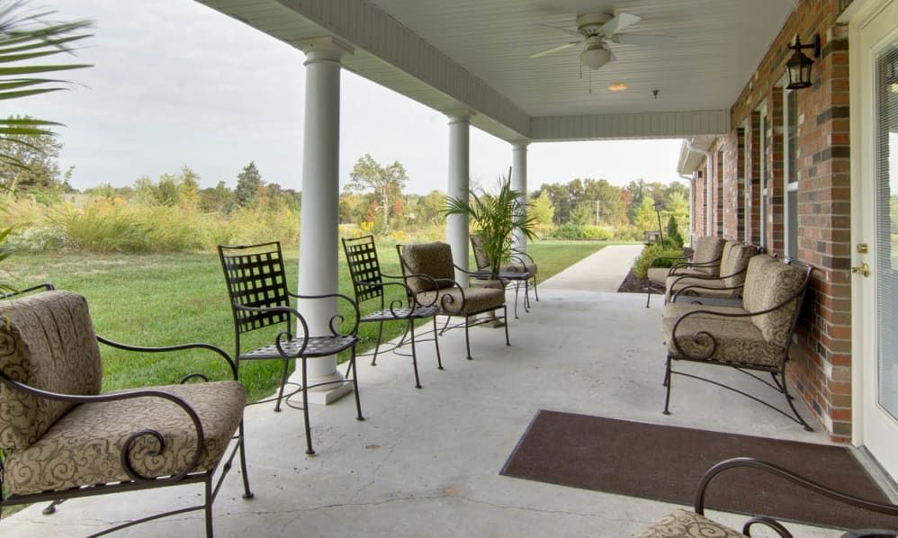 A spacious porch with comfortable seating and a view of the surrounding landscape.