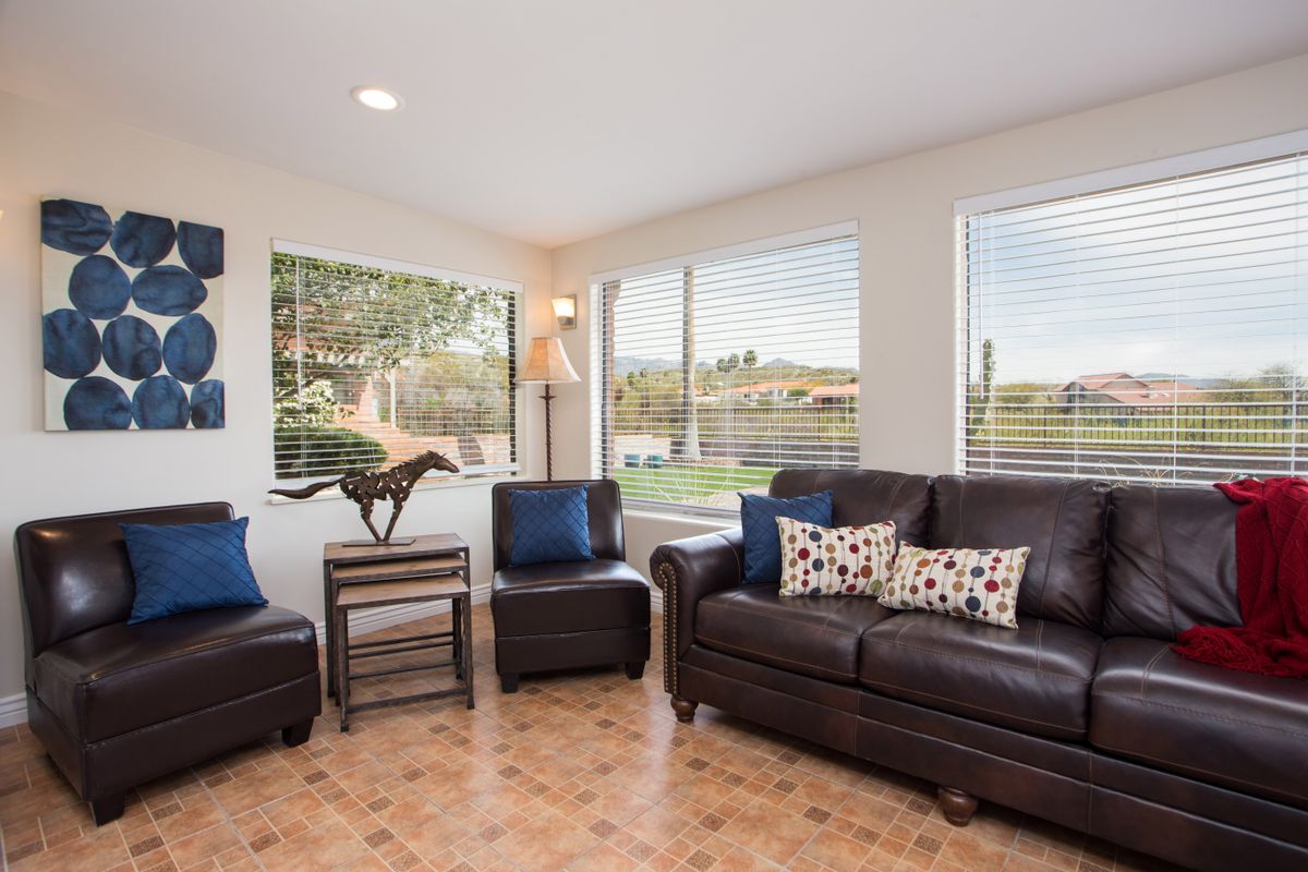 A cozy living room with dark furniture, ample natural light, and decorative accents.