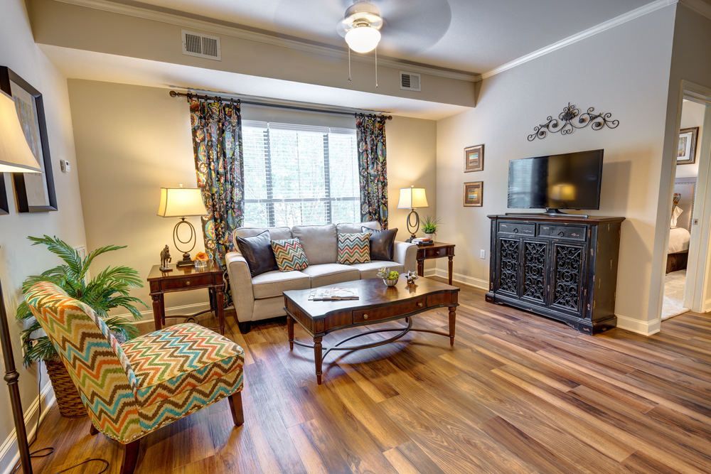 A cozy and stylish living room with wooden floors, a comfortable sofa, and elegant decor.