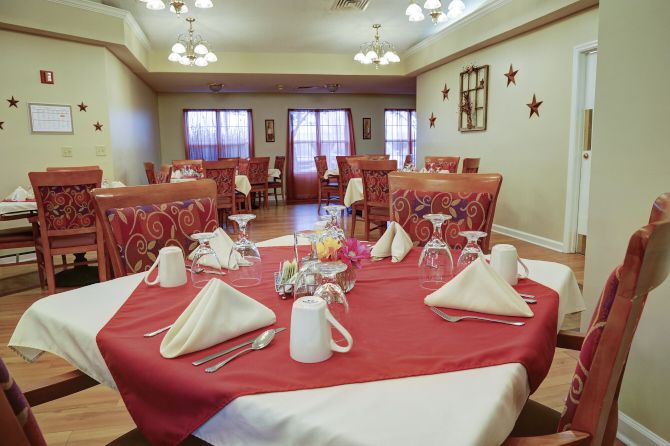 A neatly arranged dining room with tables set for guests.
