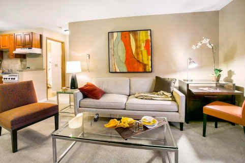 A modern living room with a stylish sofa, abstract artwork on the wall, and a glass coffee table.