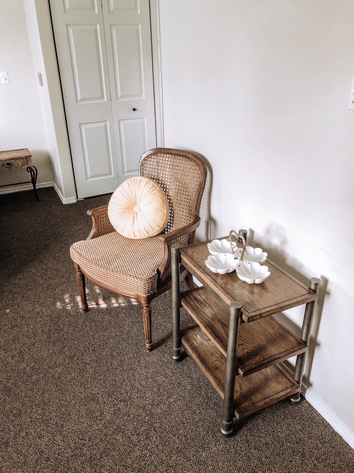 A cozy corner with an armchair and a wooden cart set for tea.