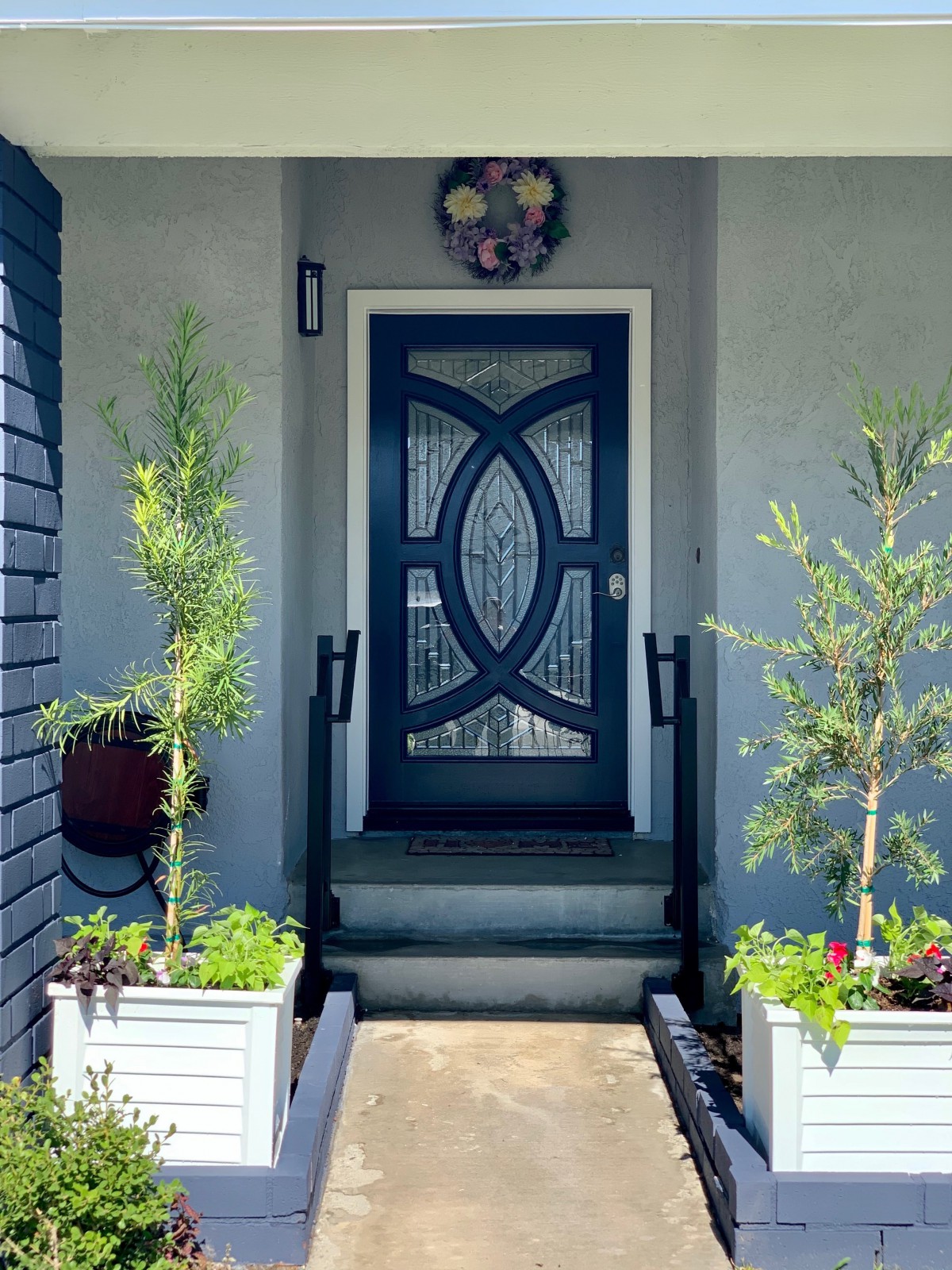 A welcoming home entrance with a stylish front door and decorative plants.