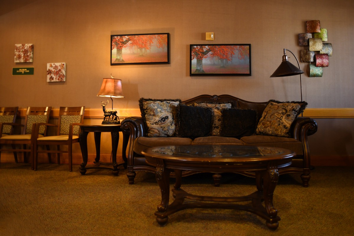 A cozy living room with a sofa, coffee table, and ambient lighting.