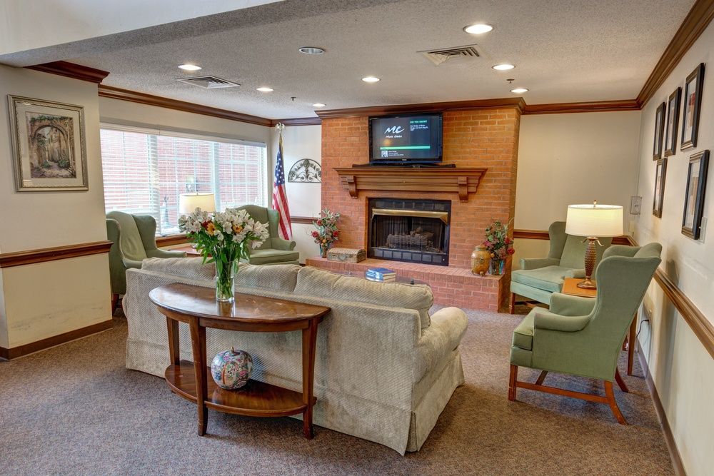 A cozy living room with comfortable seating, a fireplace, and a television.