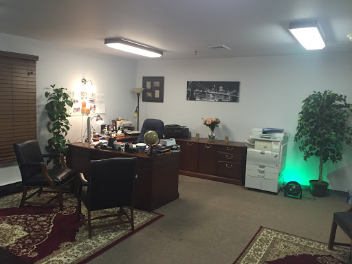 A well-organized office space featuring a desk, plants, and a printer.