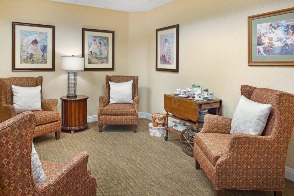 A cozy living room with armchairs and artwork on the walls.