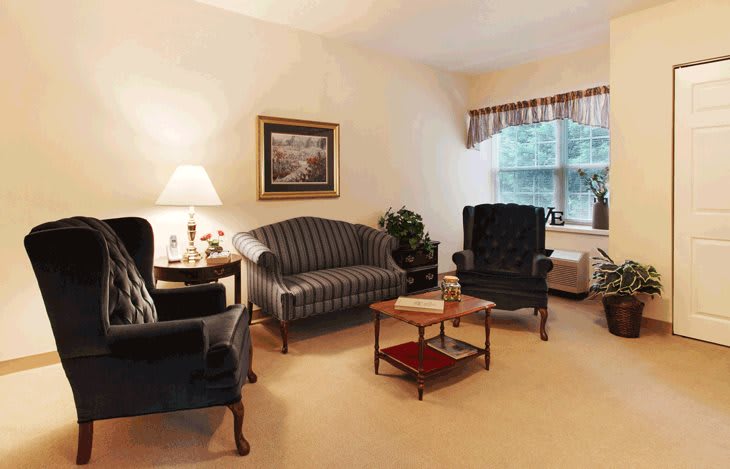 A cozy living room with a sofa, armchairs, and a coffee table.