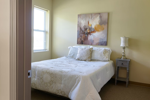 A cozy bedroom featuring a comfortable bed, stylish bedding, and decorative artwork on the wall.