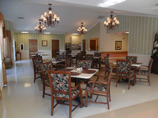A cozy dining area featuring floral-patterned chairs and elegant chandeliers, perfect for communal meals.