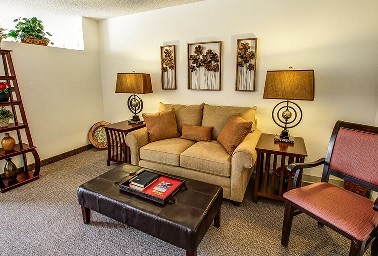 A cozy living room with a beige sofa, decorative pillows, stylish lamps, and wall art.