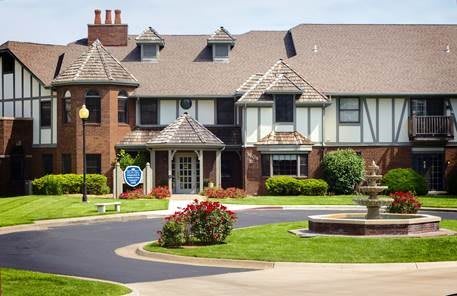 A large residential building with a landscaped garden and driveway.