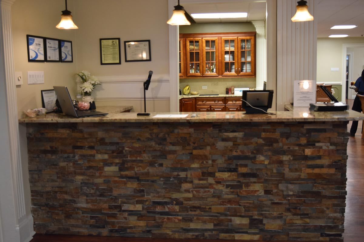 A reception desk with a stone facade in an office setting.