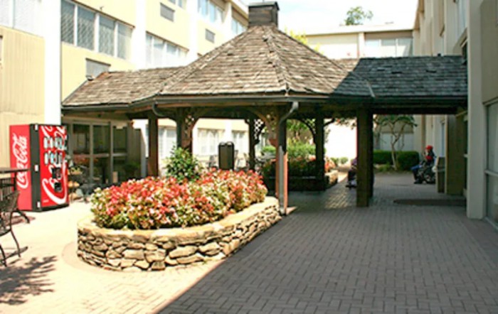 An outdoor gazebo surrounded by landscaped gardens with vibrant flowers.