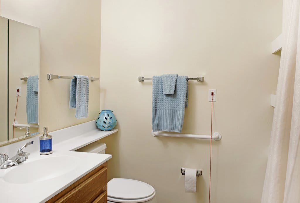 A small bathroom with light blue towels and simple decor.