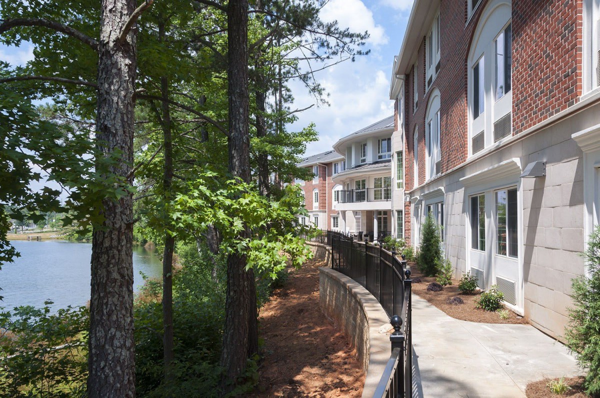 A peaceful walkway next to a modern building, surrounded by trees.