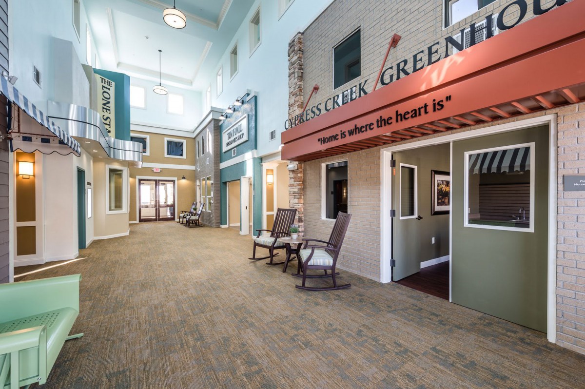 A modern indoor hallway designed to resemble a storefront street, complete with seating areas.