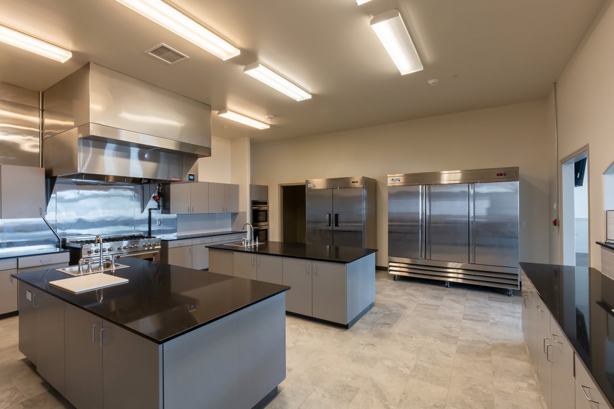 A modern industrial kitchen with stainless steel appliances and sleek countertops.