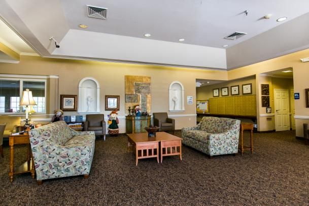 A comfortable lobby area with sofas, chairs, and artwork on the walls.