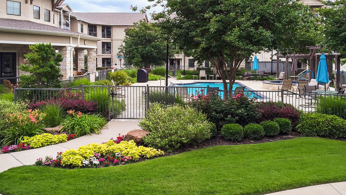 A well-maintained apartment complex with landscaped gardens and a swimming pool.