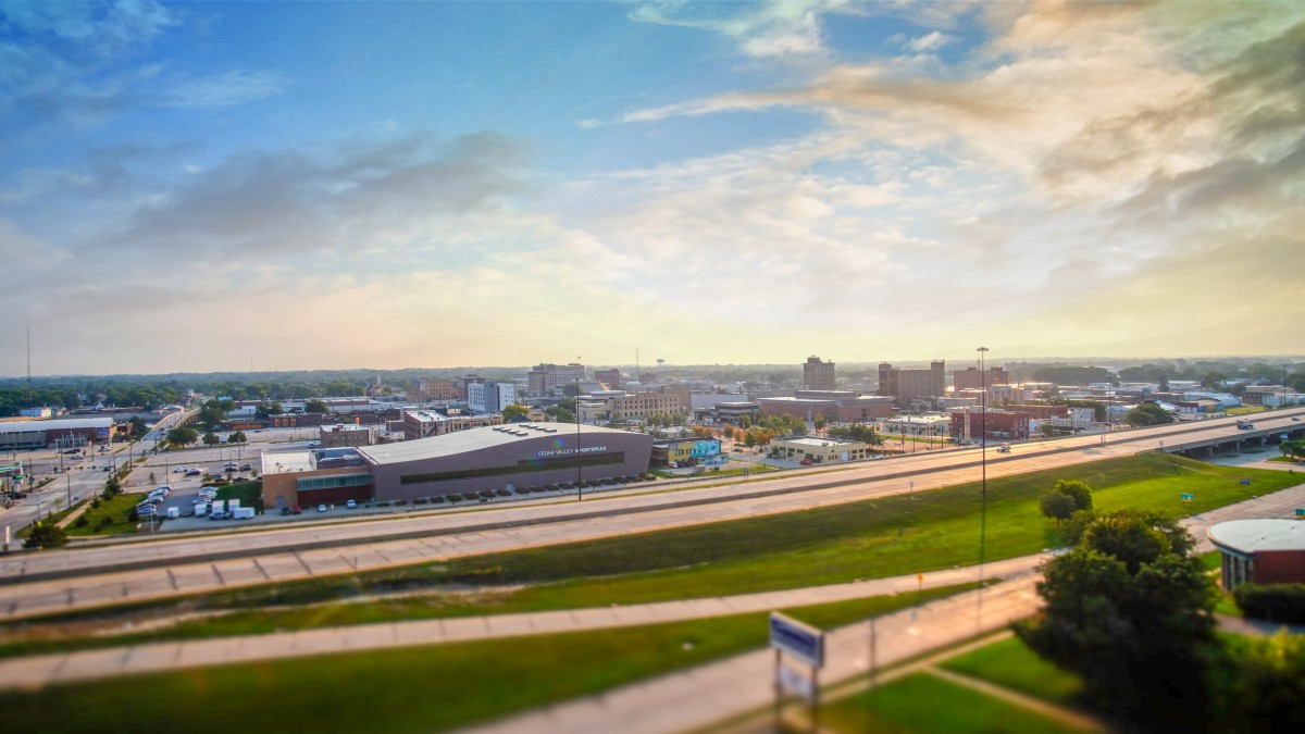 A panoramic view of a city skyline with roads and modern buildings under a vibrant sky.