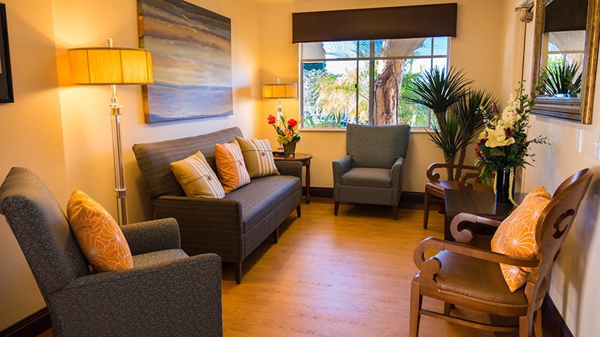A cozy living room with a sofa, armchairs, and decorative elements enhancing a warm atmosphere.