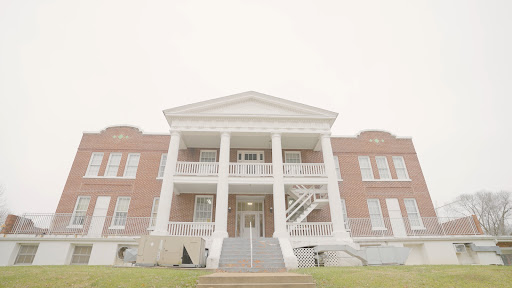 A stately building featuring classical architecture with prominent columns and a welcoming front entrance.