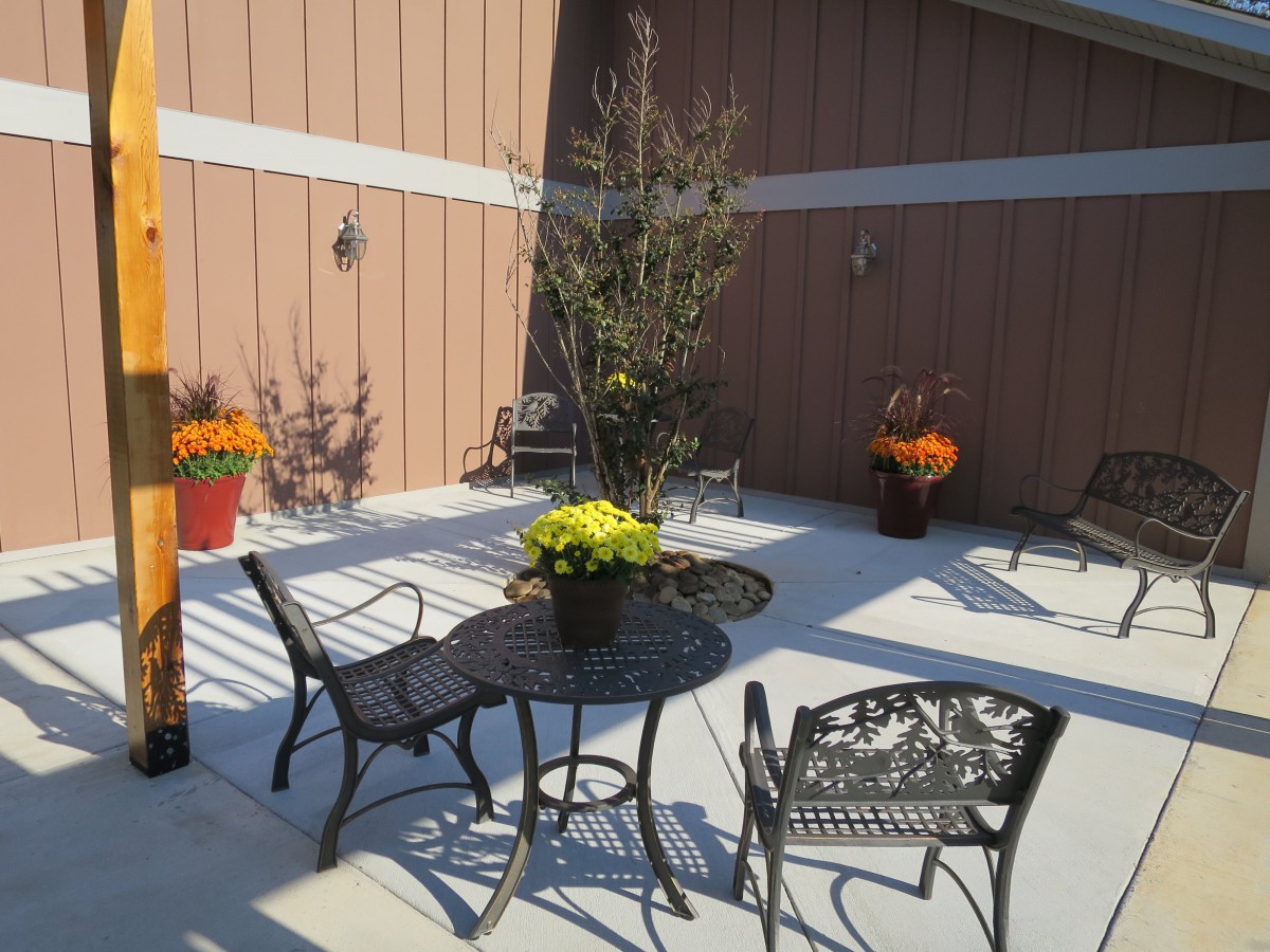 A sunny outdoor patio area with metal furniture and potted plants.