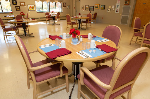 A well-prepared dining area with a round table set for guests, featuring decorative elements and an inviting atmosphere.