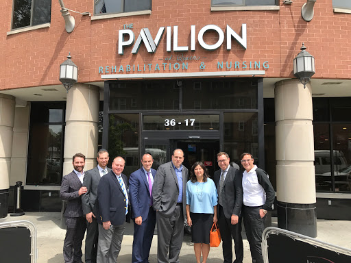 A group of professionals gathered outside the Pavilion for a meeting.